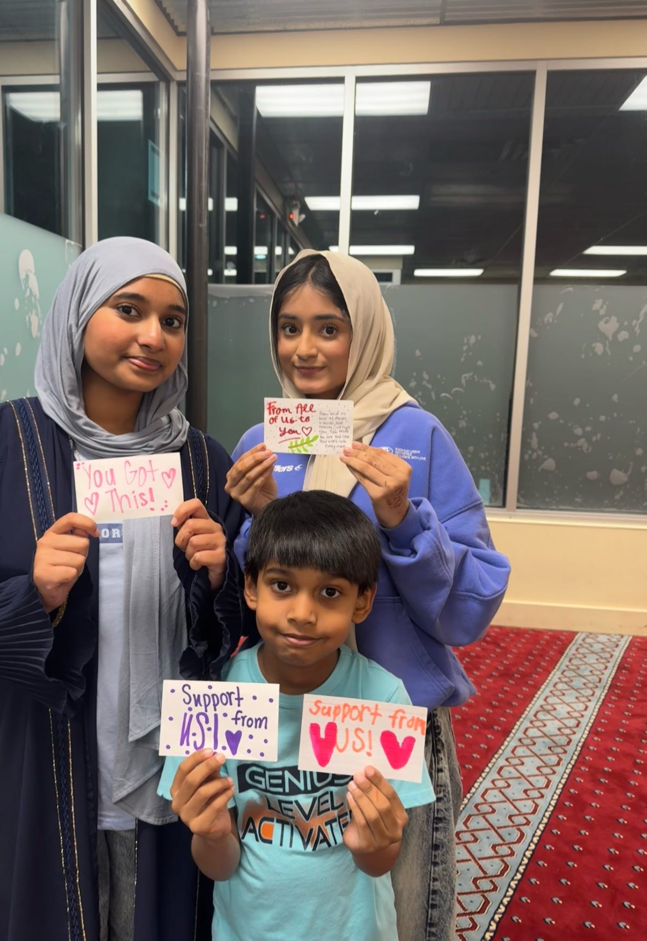 Student volunteers holding handwritten cards for cancer patients